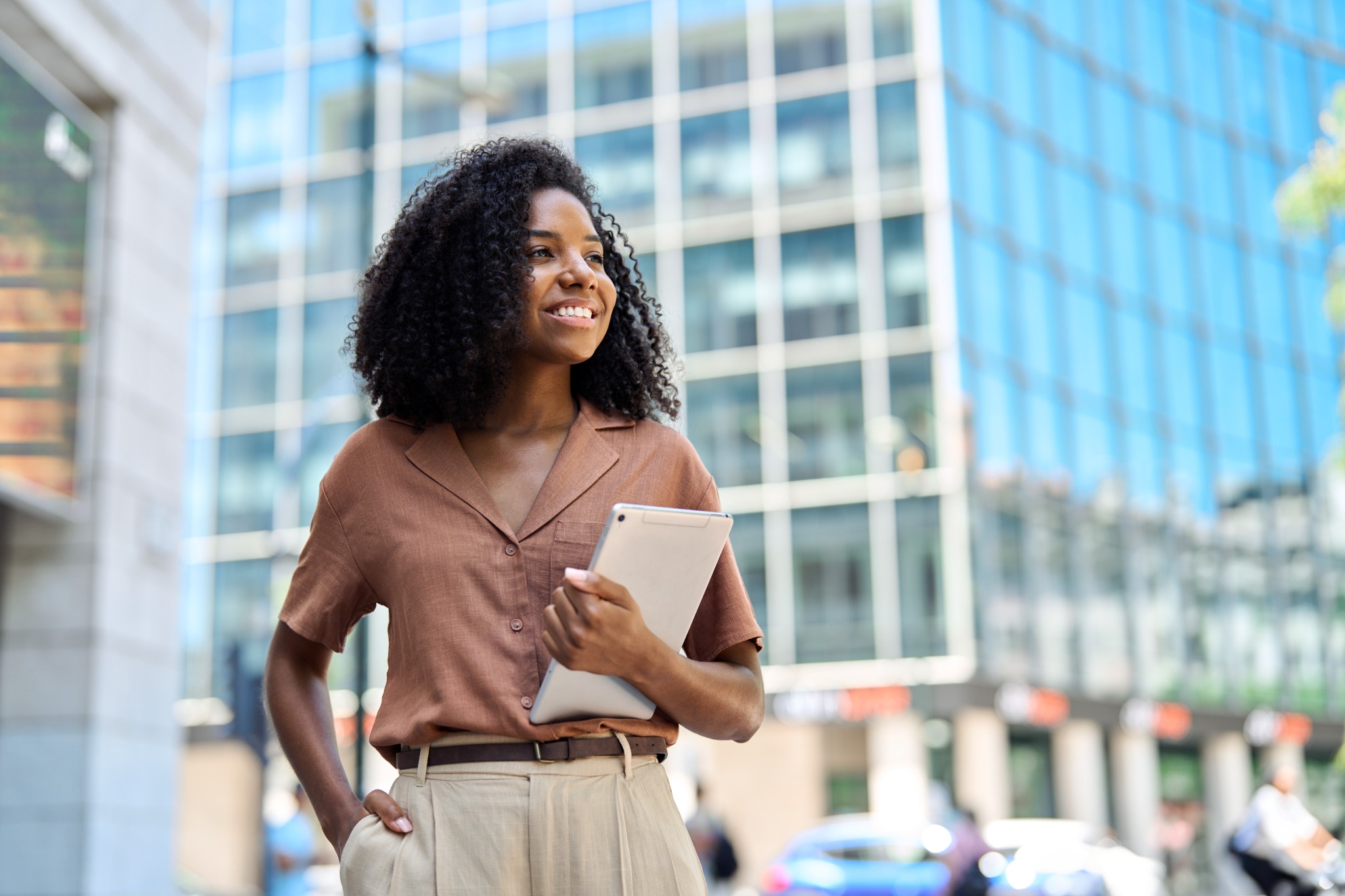 Banking professional holding a tablet outside a modern office building